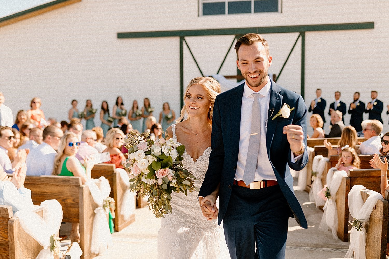A bride and groom leaving their wedding ceremony at The Butler Barn.