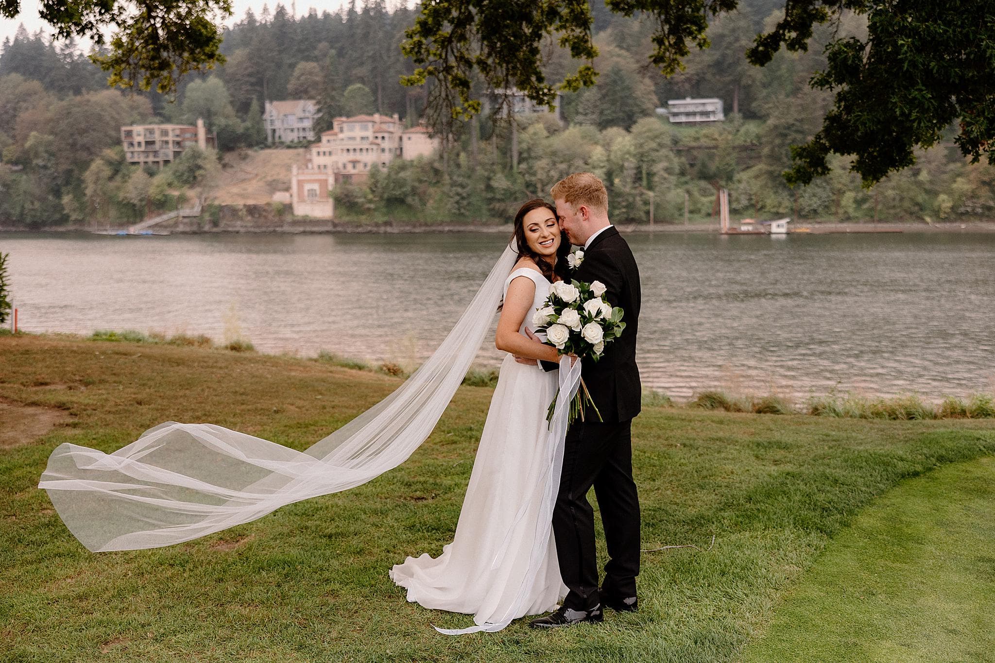 A bride and groom share a tender moment along the river in Lake Oswego, Oregon. 
