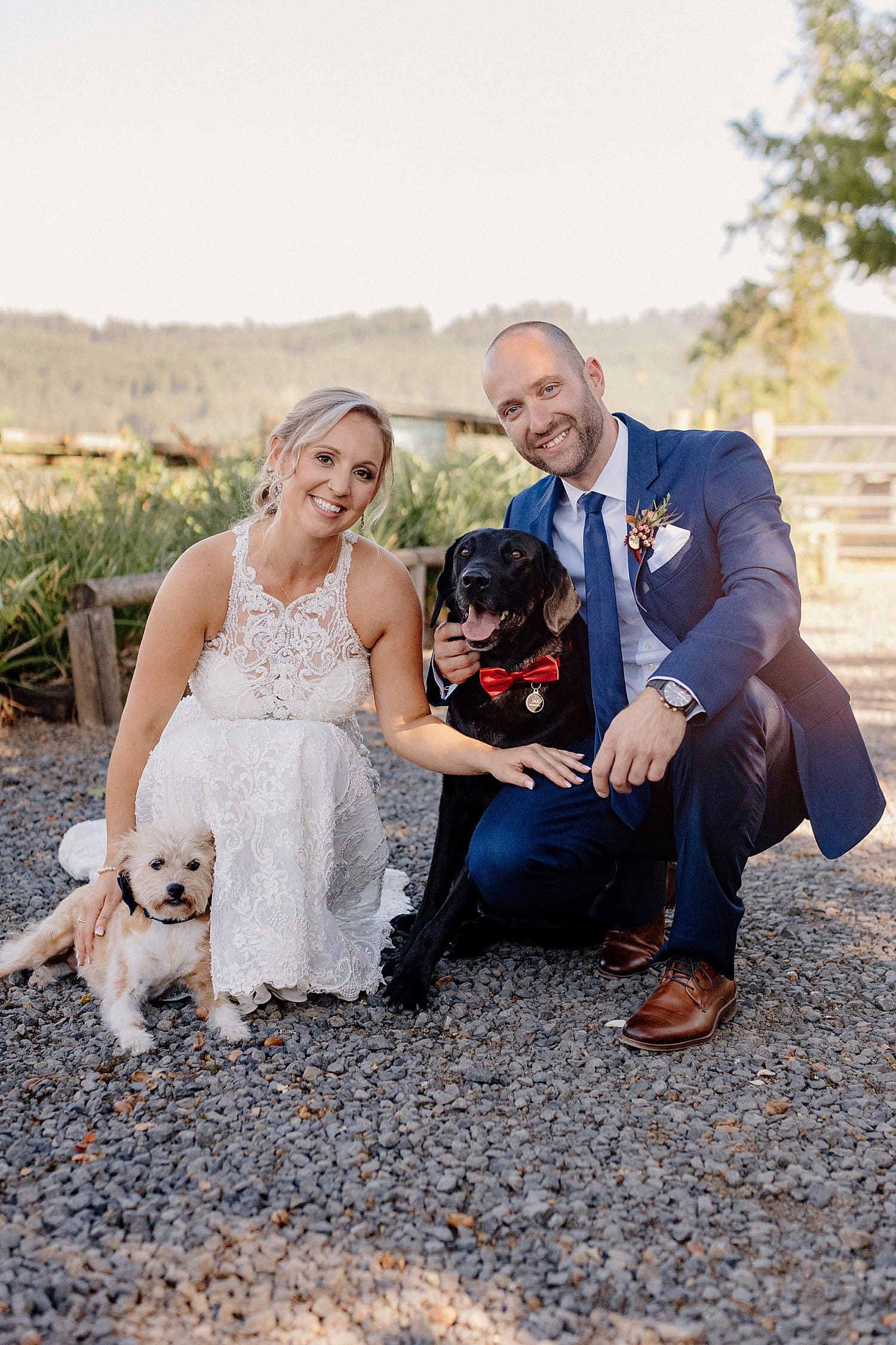 A bride and groom pose with their dogs at Abbey Road Farm.
