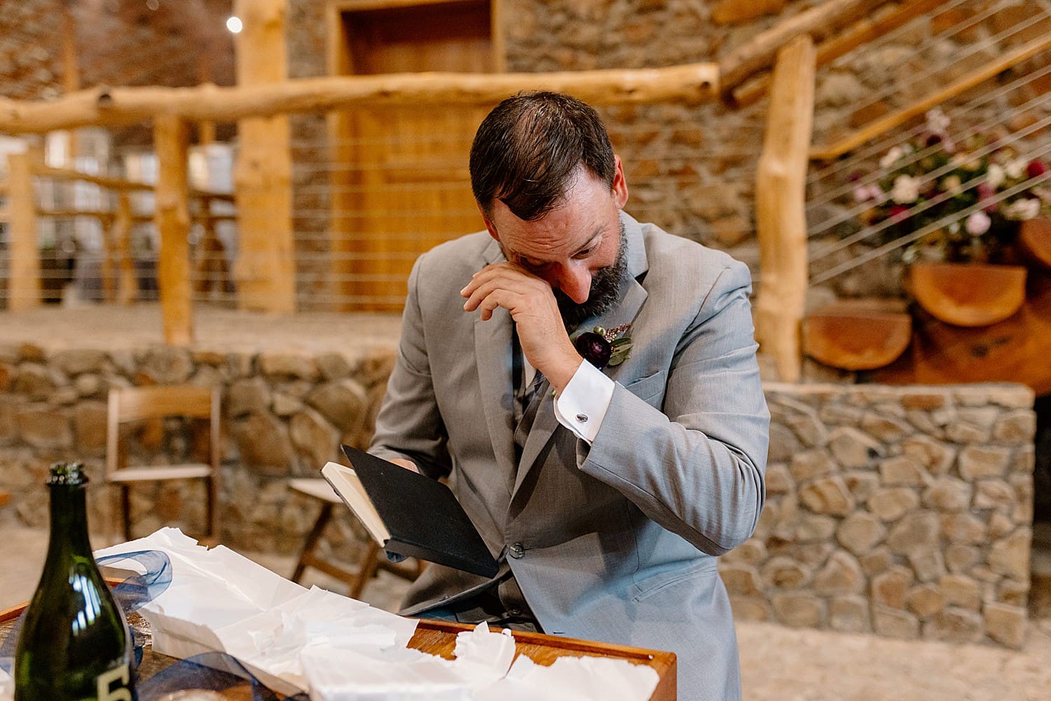 A groom tearing up reading a card from his bride at Maysara Winery.
