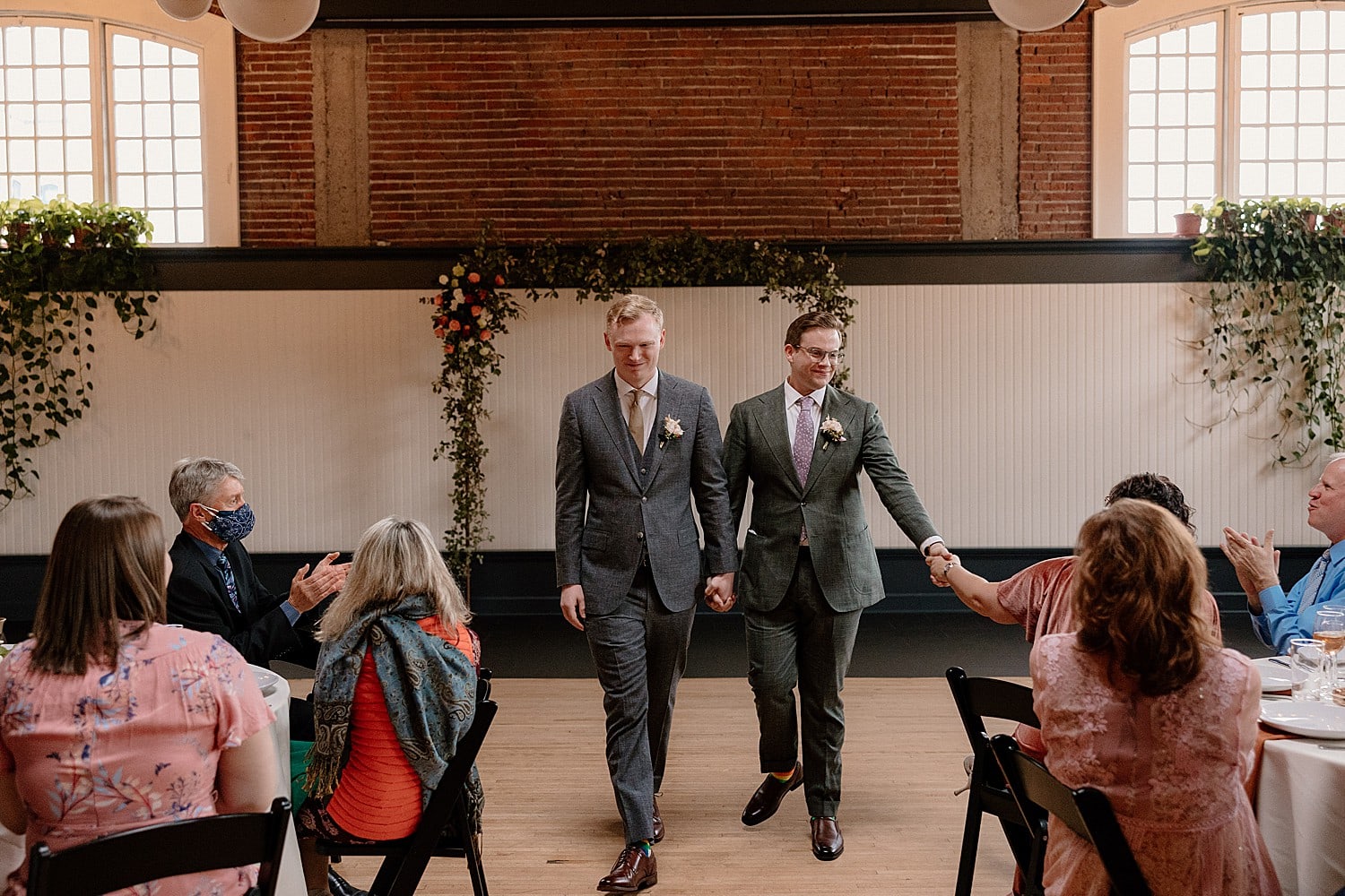 Two grooms exit their wedding ceremony at The Evergreen in Portland.