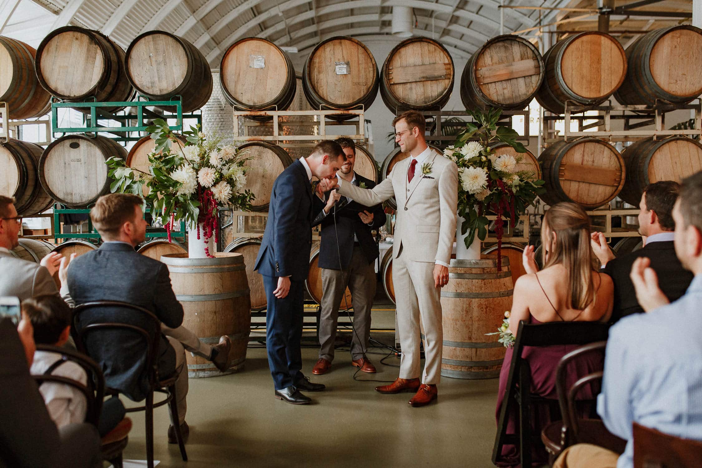 A same sex couple kissing during their Cooper's Hall wedding ceremony