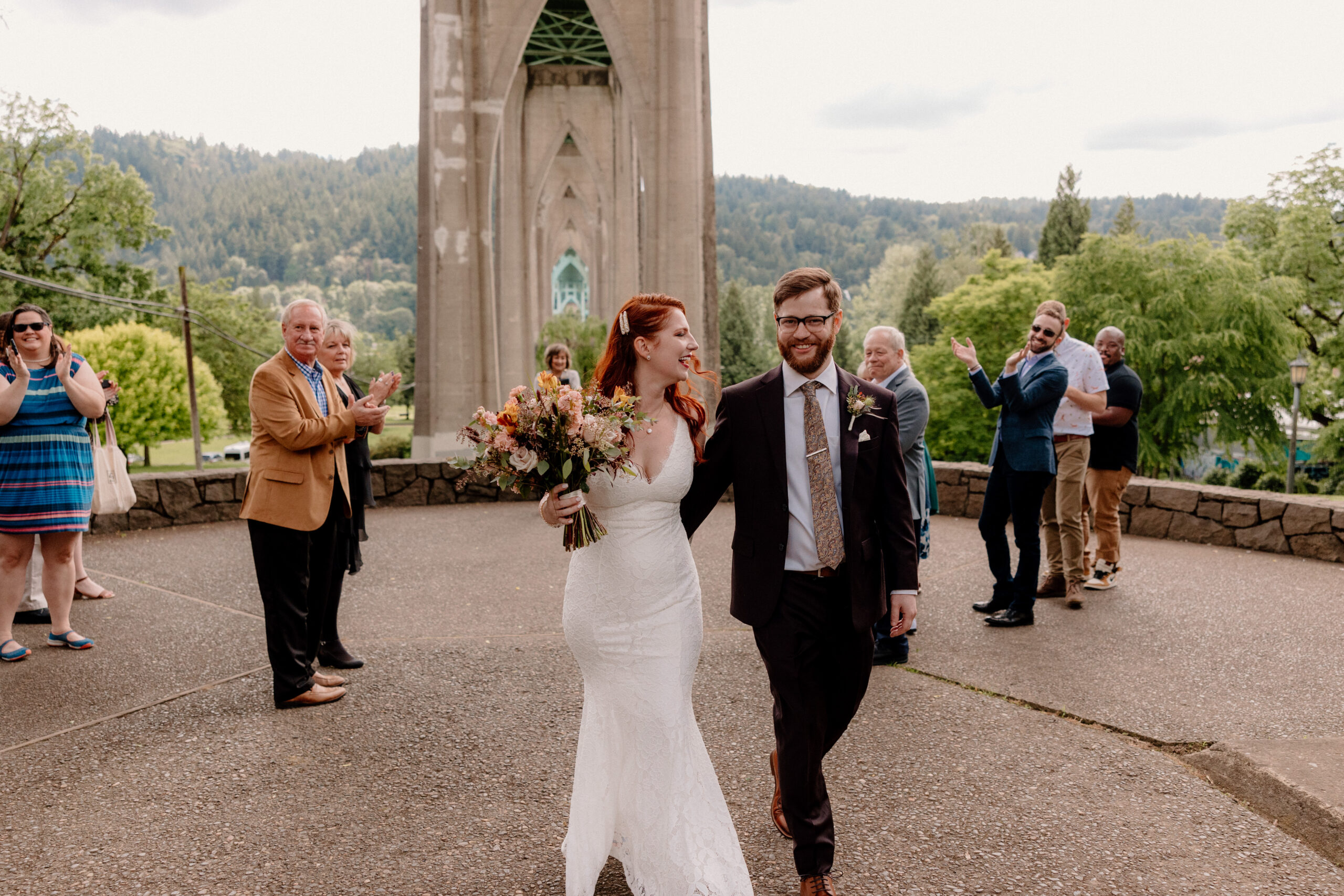 Guests cheering on a happy couple after their Cathedral Park elopement ceremony.