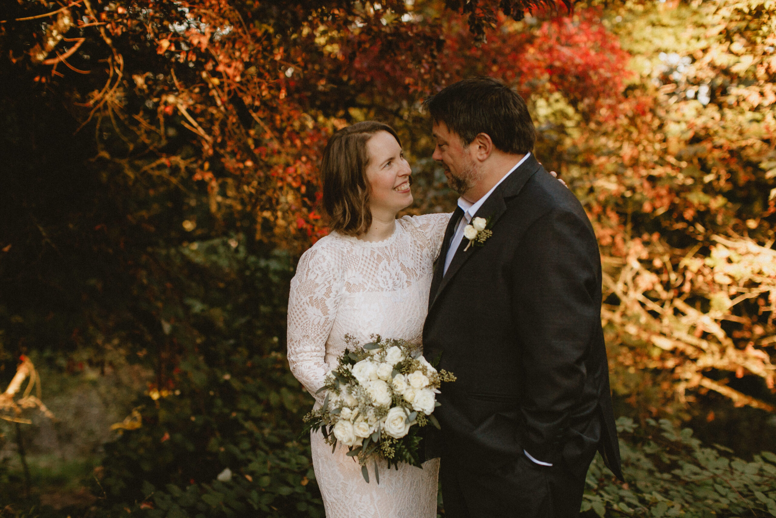 A couple embracing during their fall Mt. Tabor elopement ceremony in Portland. 