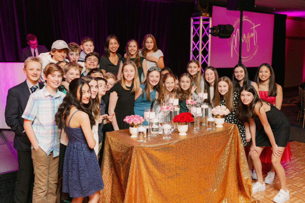 A girl and her friends pose for a group photo during a candle lighting ceremony at her bat mitzvah at the Mac Club.