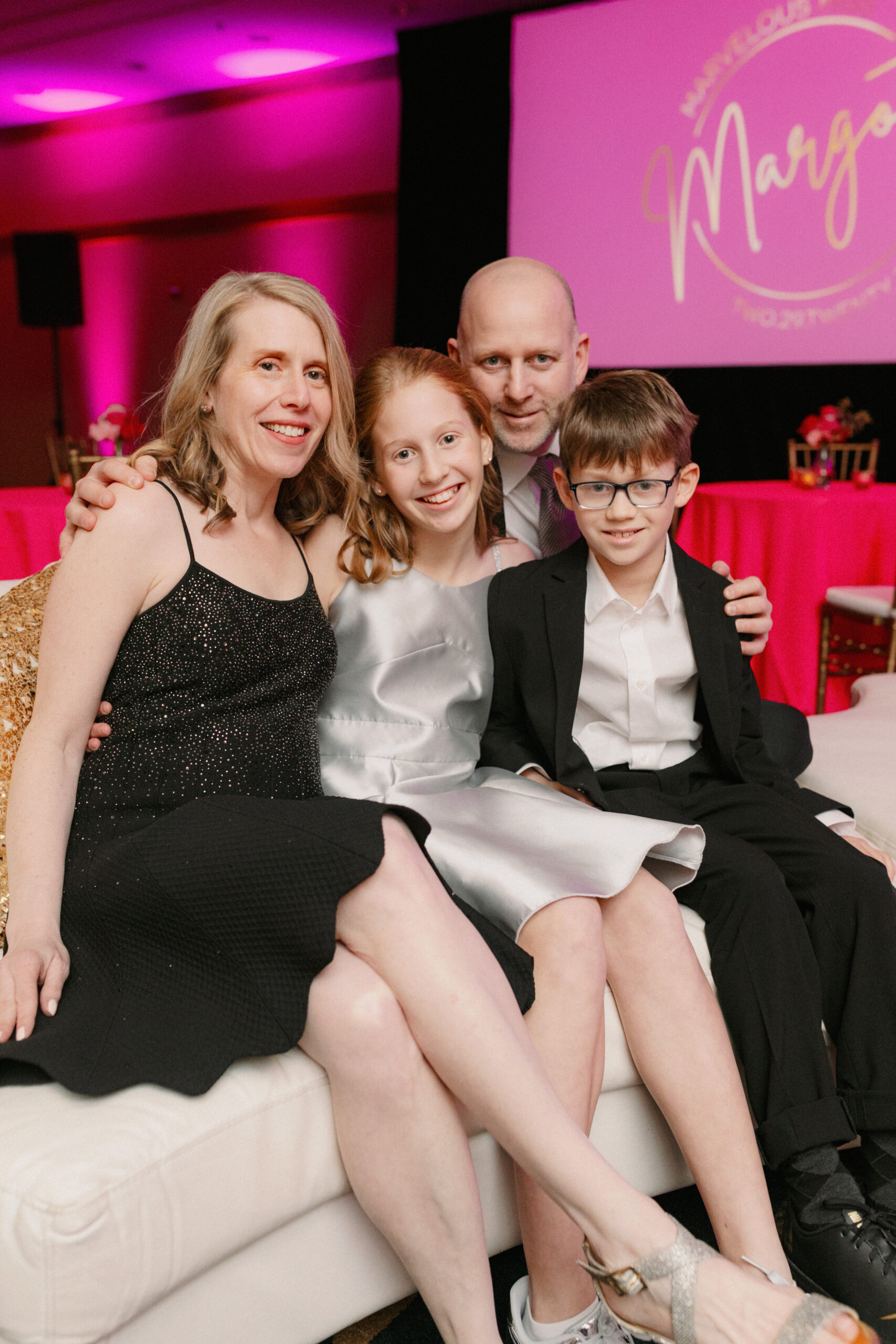 A family posing for formal portraits during a bat mitzvah celebration at the Mac Club in Portland.
