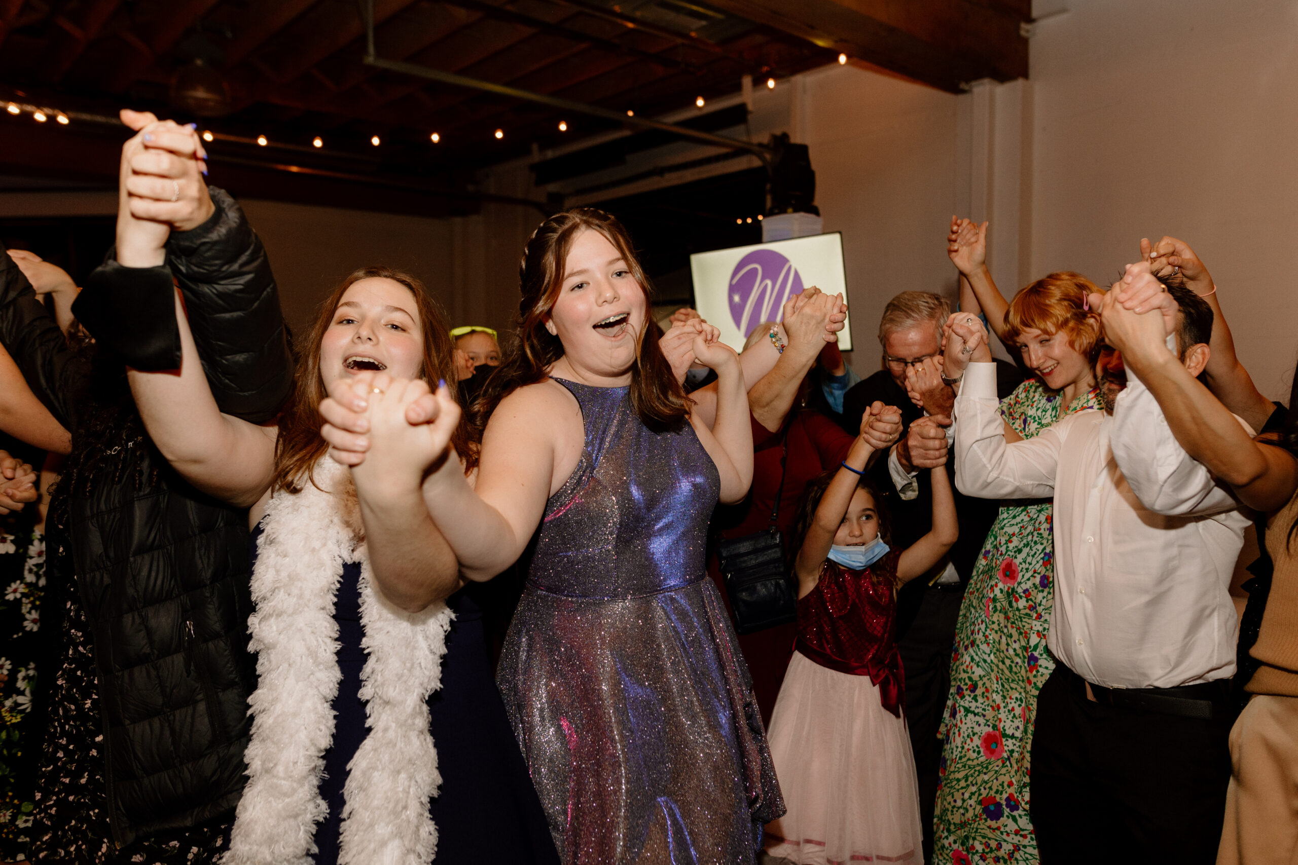 Children laughing and dancing after the hora at a bat mitzvah party at the Castaway in Portland.