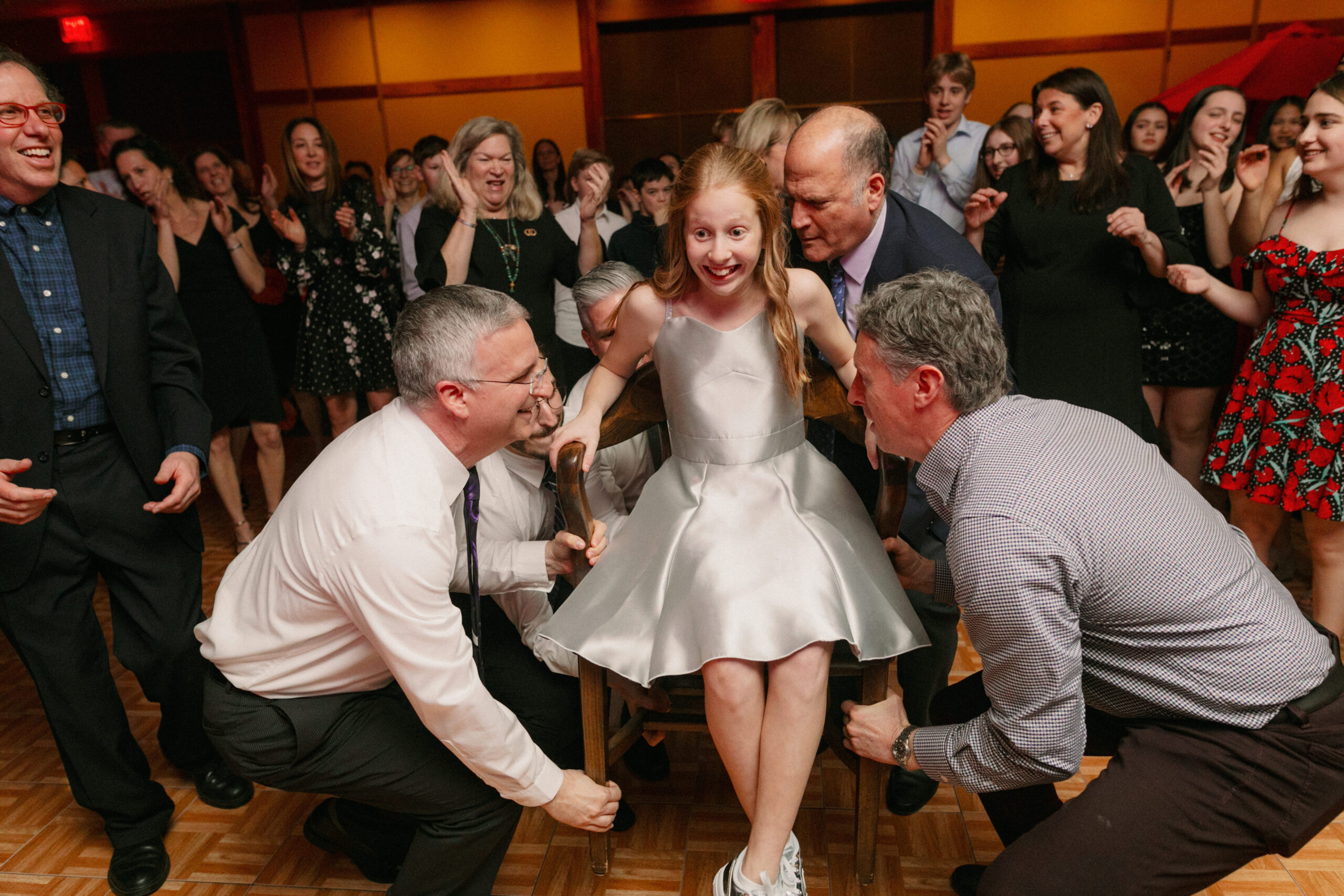 Guests raising a child up for the hora during her bat mitzvah party at the Mac Club in Portland.