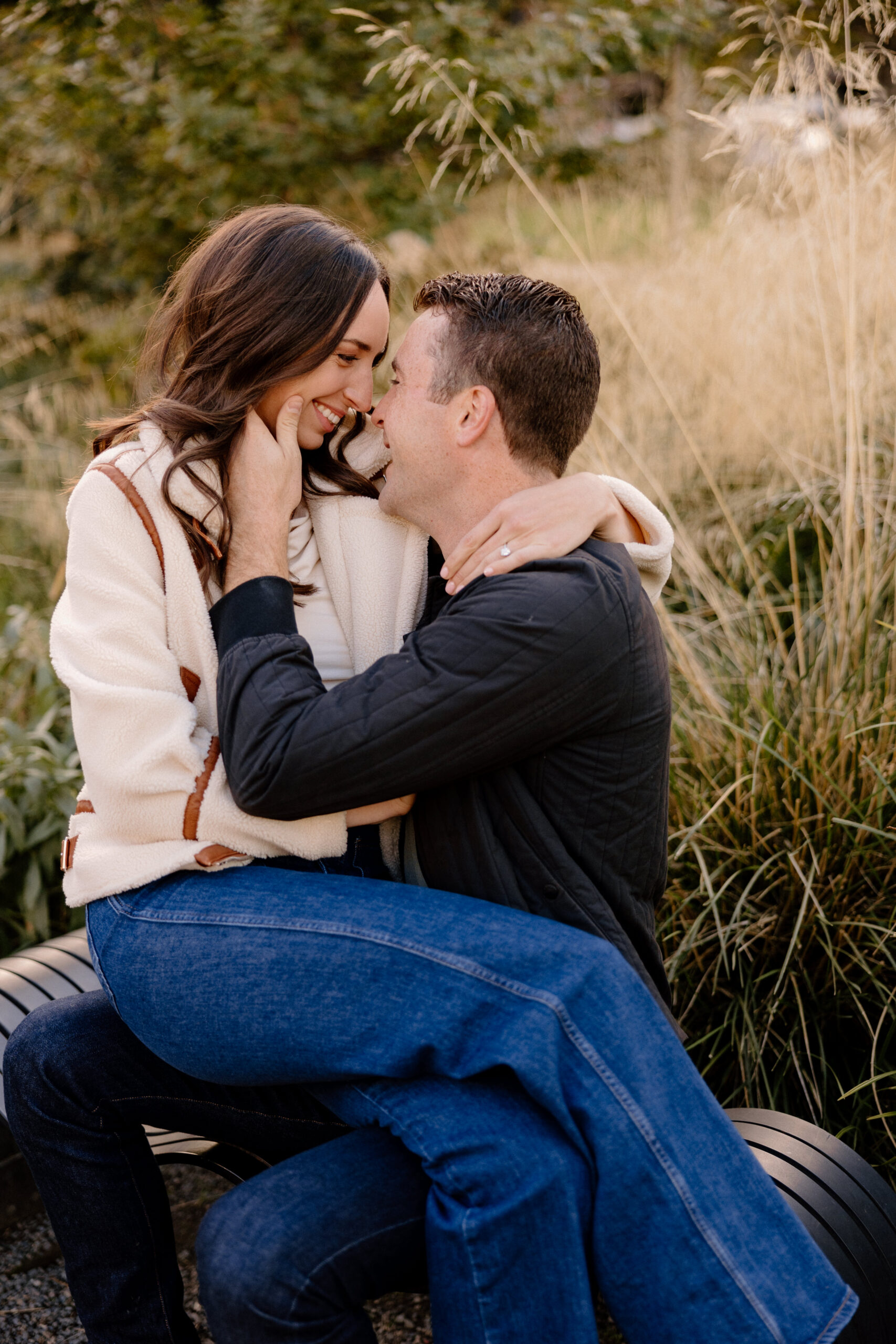 A couple cuddling during their engagement session at Tanner Springs Park in Portland. 